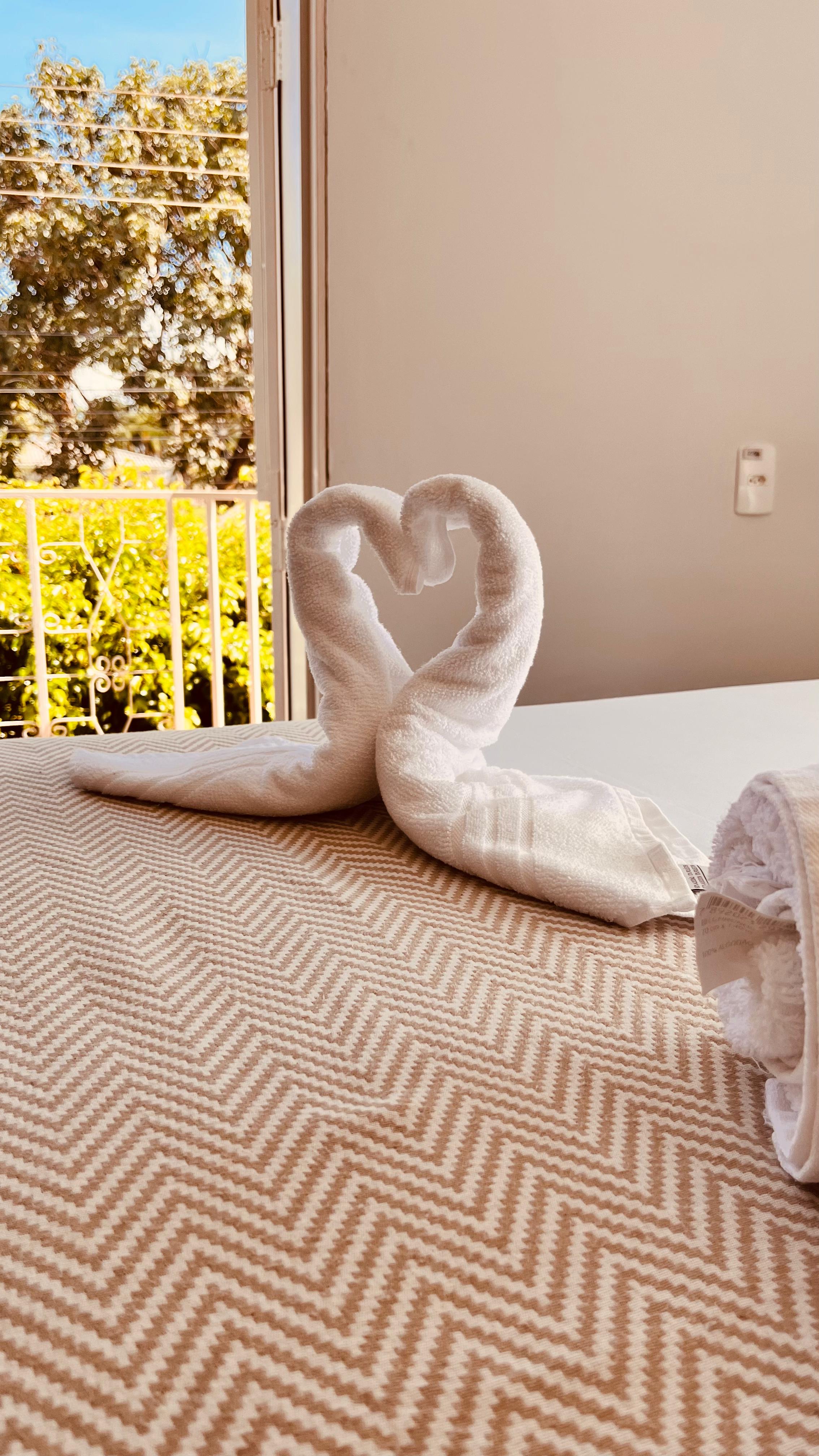 Luxo Single — detalhe da cama com toalhas decorativas